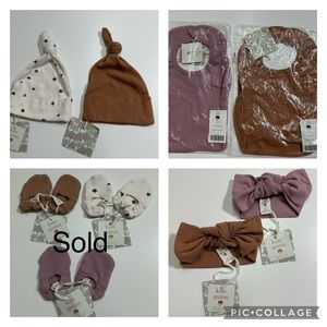 Bundle of Kate Quinn organic cotton baby bibs, hats, head bands, footies.